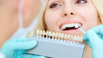 Erleben Sie die Magie eines strahlenden Lächelns in der barrierefreien Zahnarztpraxis 'Zahnärzte am Sterntor'. Unsere erfahrene Spezialistin berät eine Patientin bei der Auswahl der perfekten Zahnfarbe. In einer entspannten Atmosphäre auf dem barrierefreien Behandlungsstuhl, wird jedes Detail für das strahlende Lächeln besprochen. Vertrauen Sie unseren Experten für Ihre professionelle Zahnaufhellung und Zahnkosmetik.